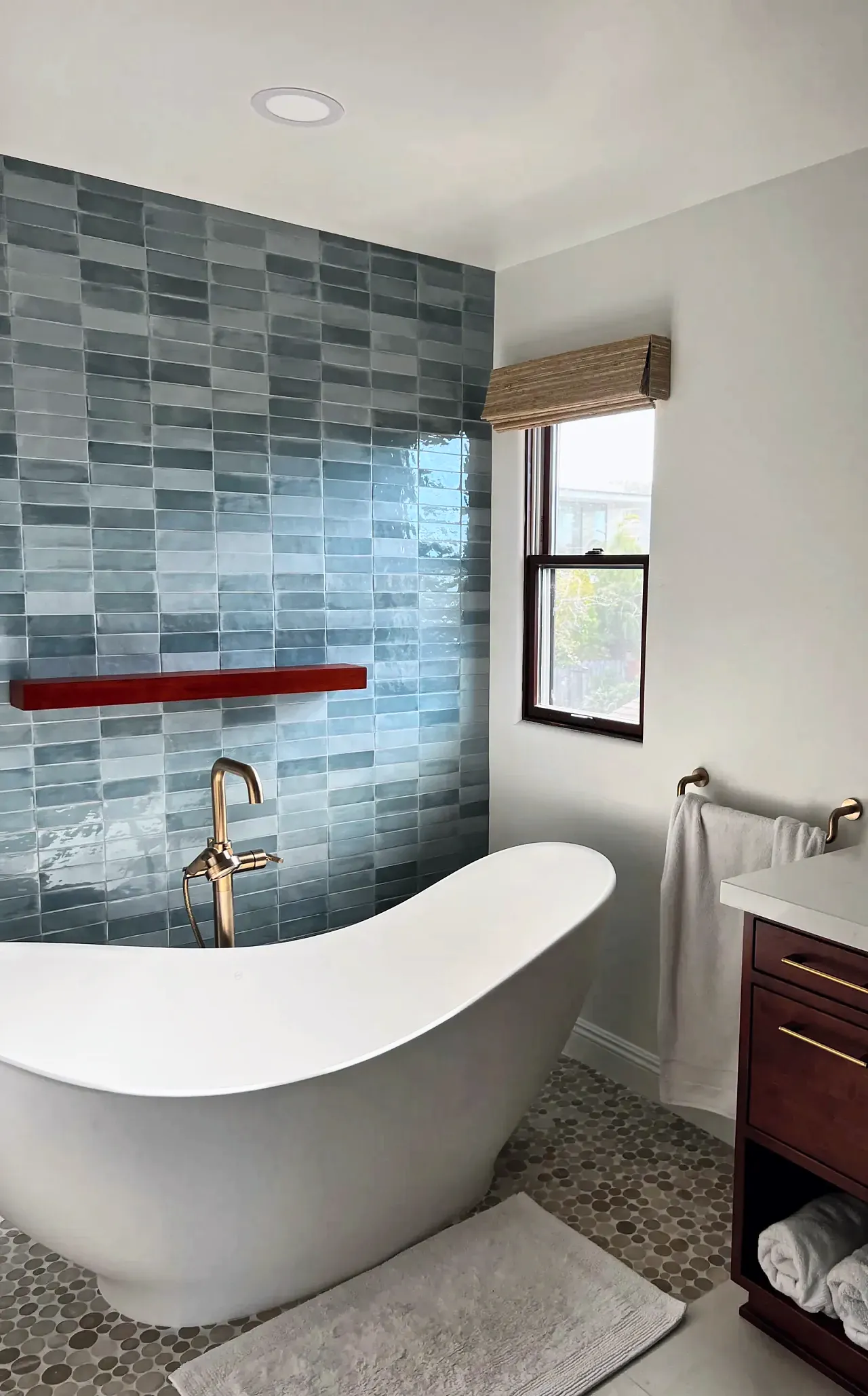 Slipper tub corner where the blue tile accent wall meets the white wall