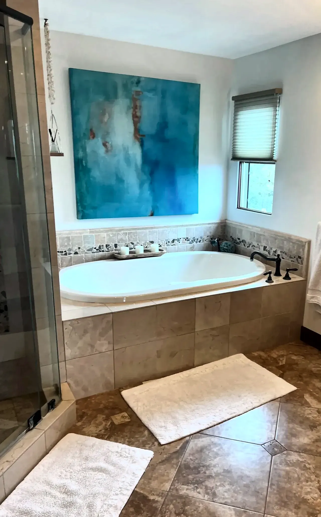 Primary bathroom before the remodel, with a drop-in tub in beige tile