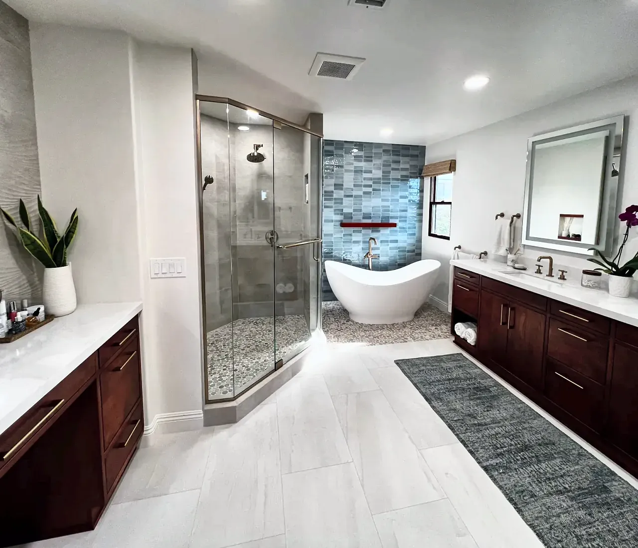 Del Mar primary bathroom with a glass shower, freestanding tub and blue tile feature wall
