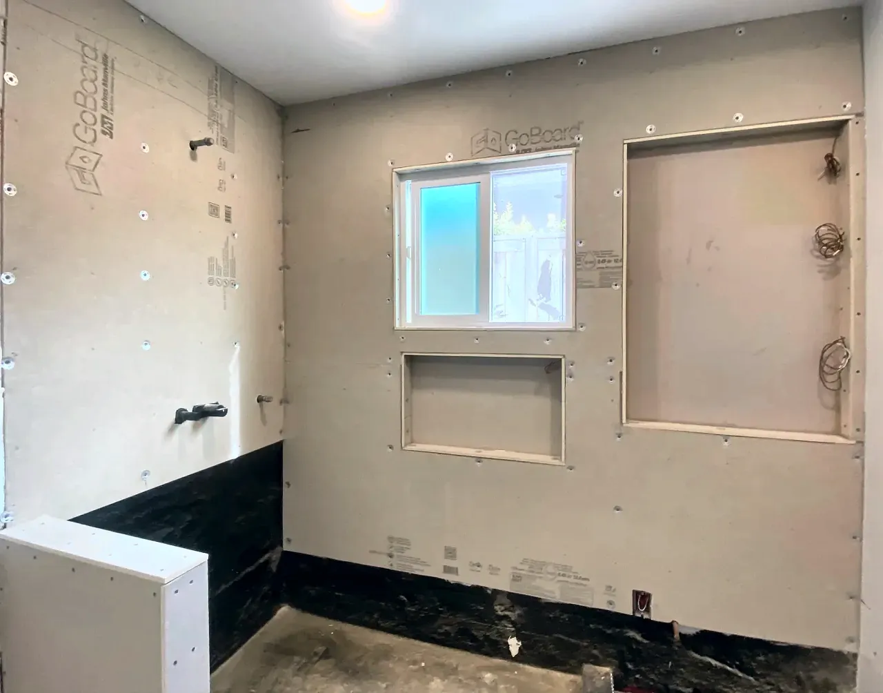 A Del Mar shower at the backer-board stage, with the window, niche and tall niche openings framed before tile