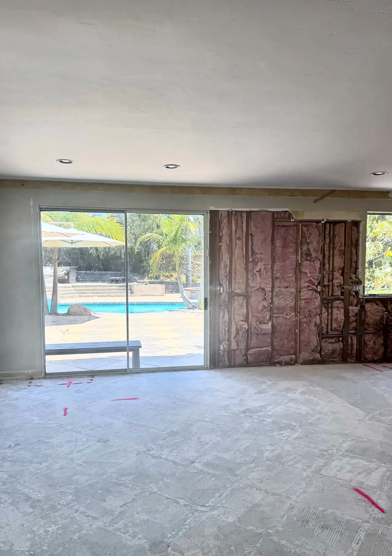 The family room wall before, with an old sliding door and the wall opened to the studs