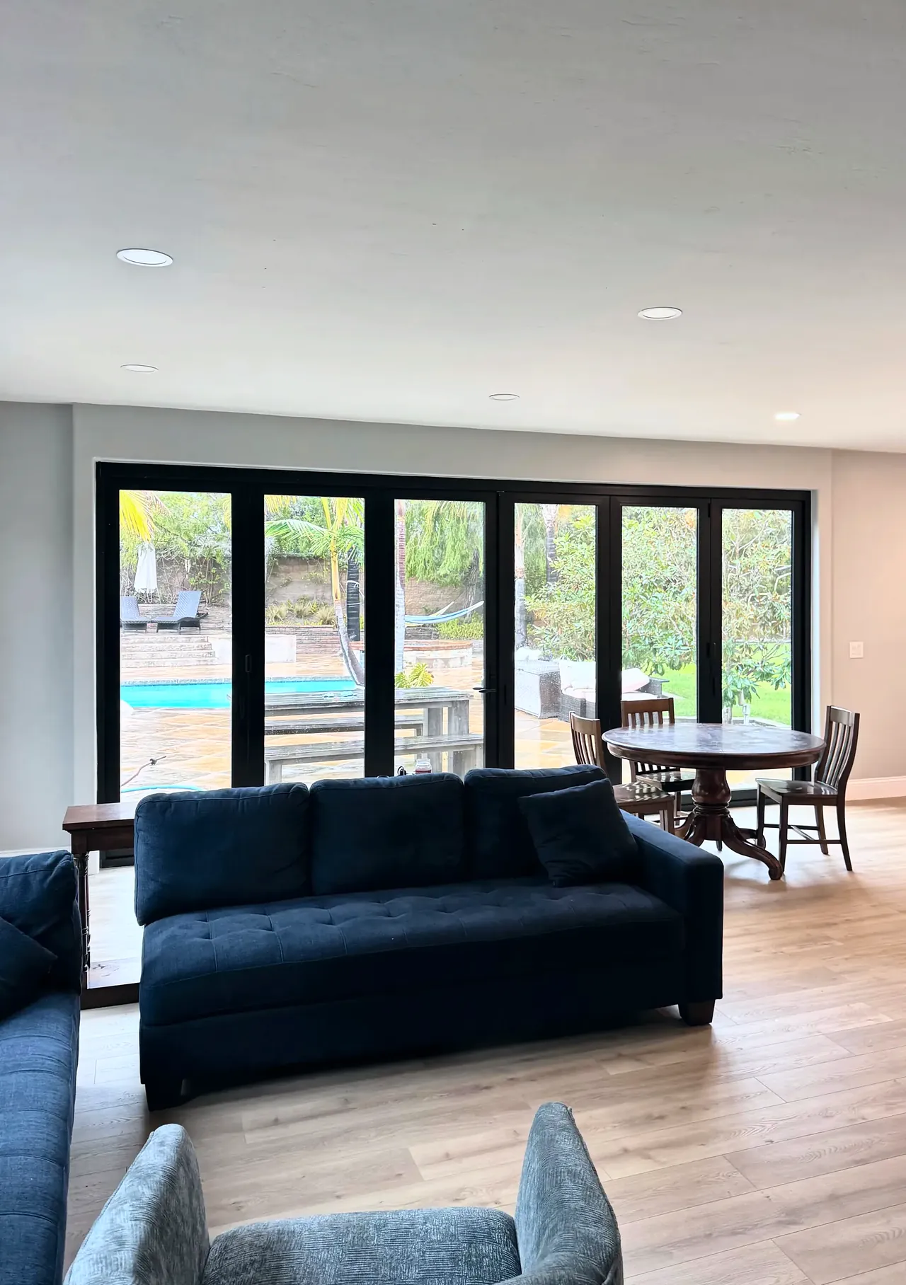 Six-panel black bifold door opening the family room to the patio and pool