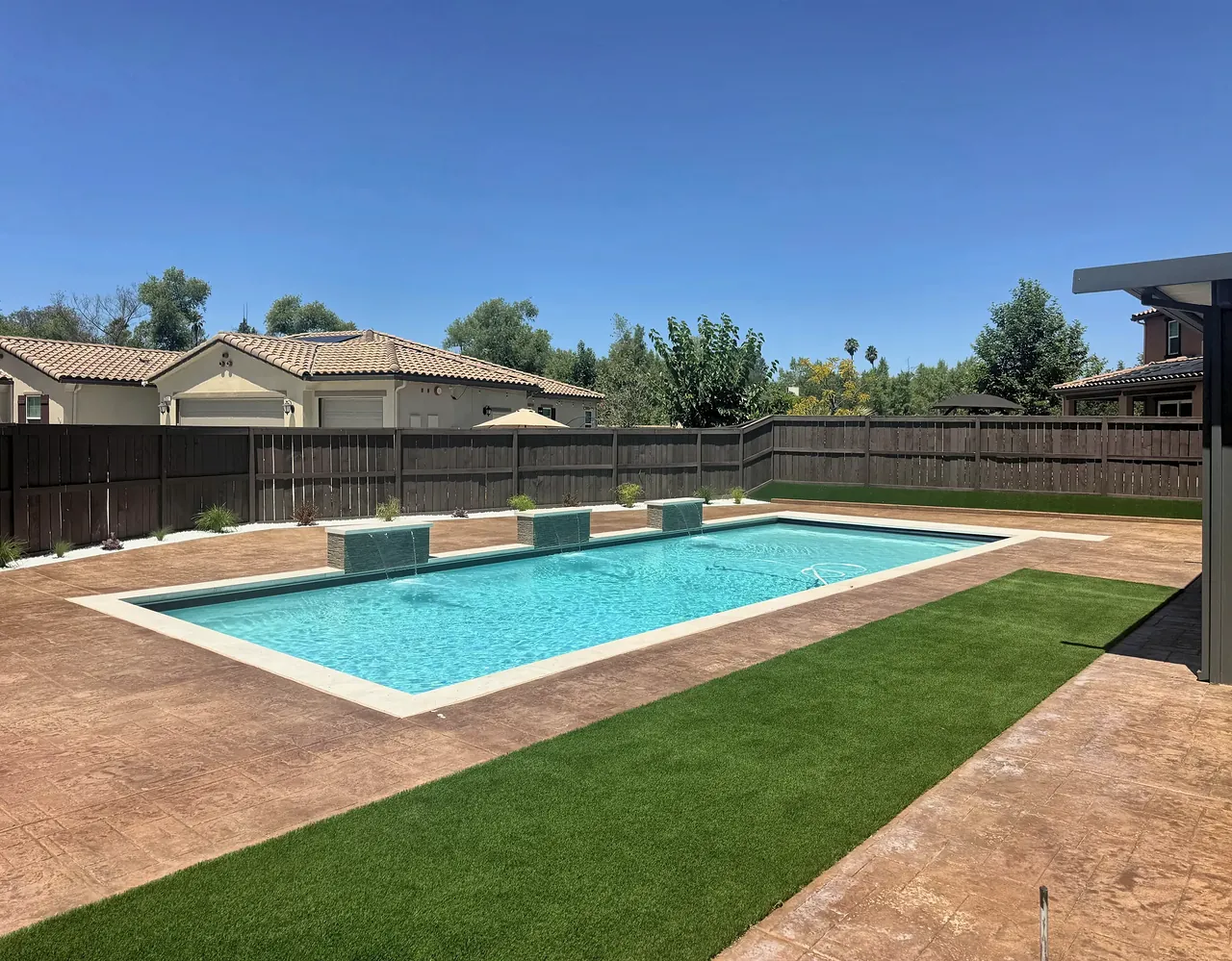 Finished backyard with the pool, deck and lawn