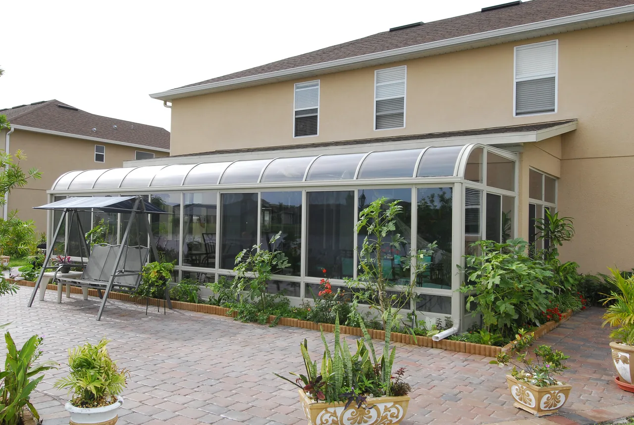 Four Seasons Curved sunroom on the back of a two-story home