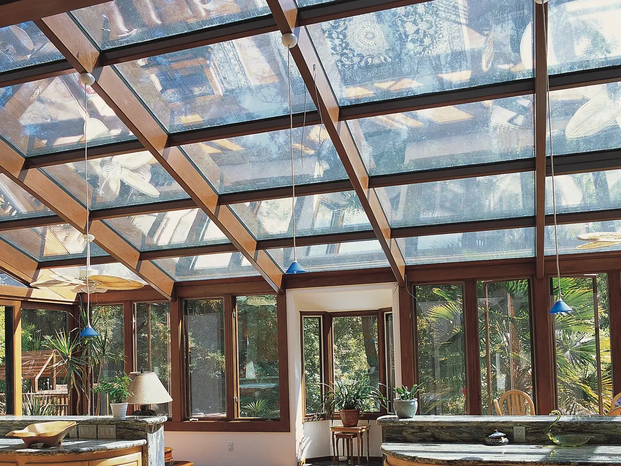 Four Seasons Studio glass roof sunroom with wood rafters over a kitchen
