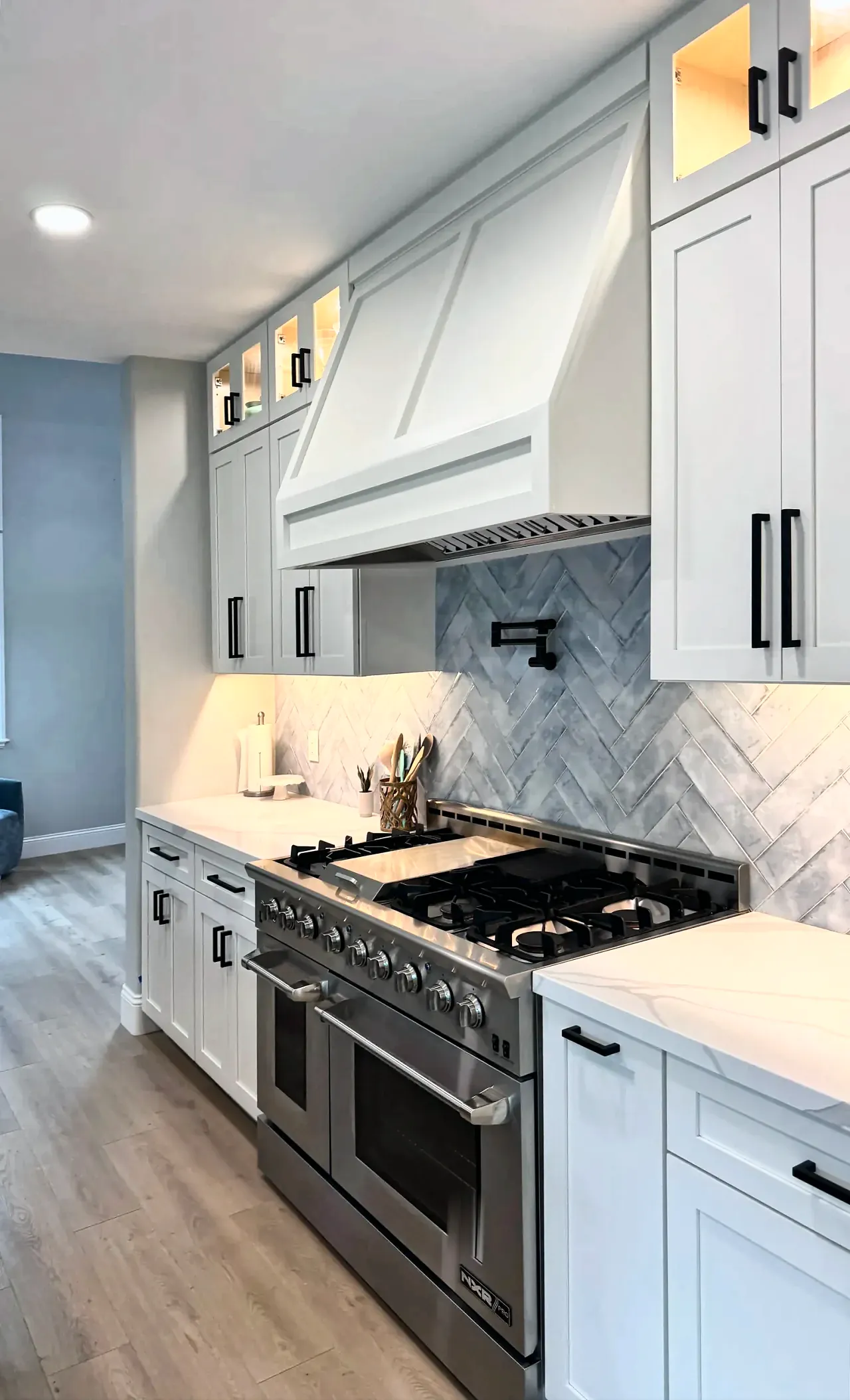 Closer view of the range, the herringbone backsplash and the painted hood