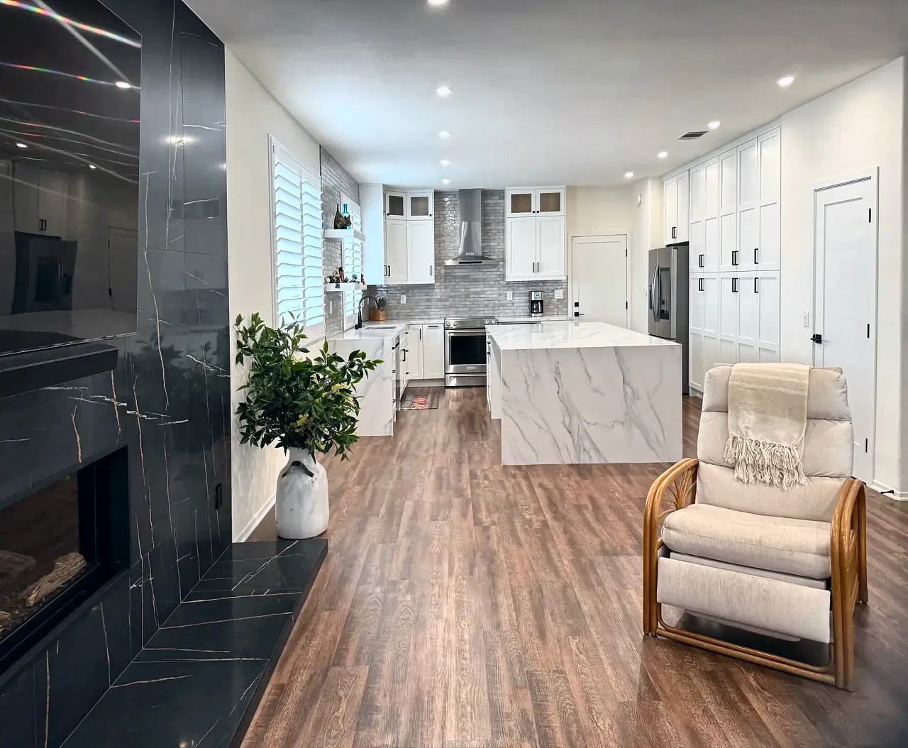 Open kitchen and living area with a black and gold porcelain fireplace wall in the foreground