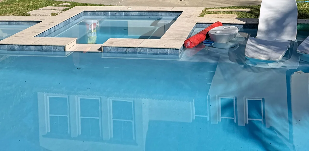 The finished spa and pool, with blue waterline tile and light coping