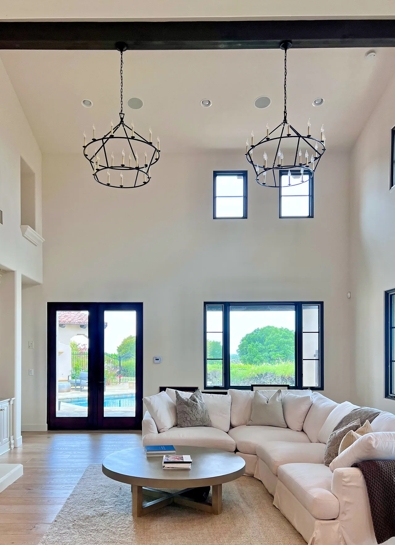 Living room in a Santaluz whole-home remodel, with a vaulted ceiling and iron chandeliers