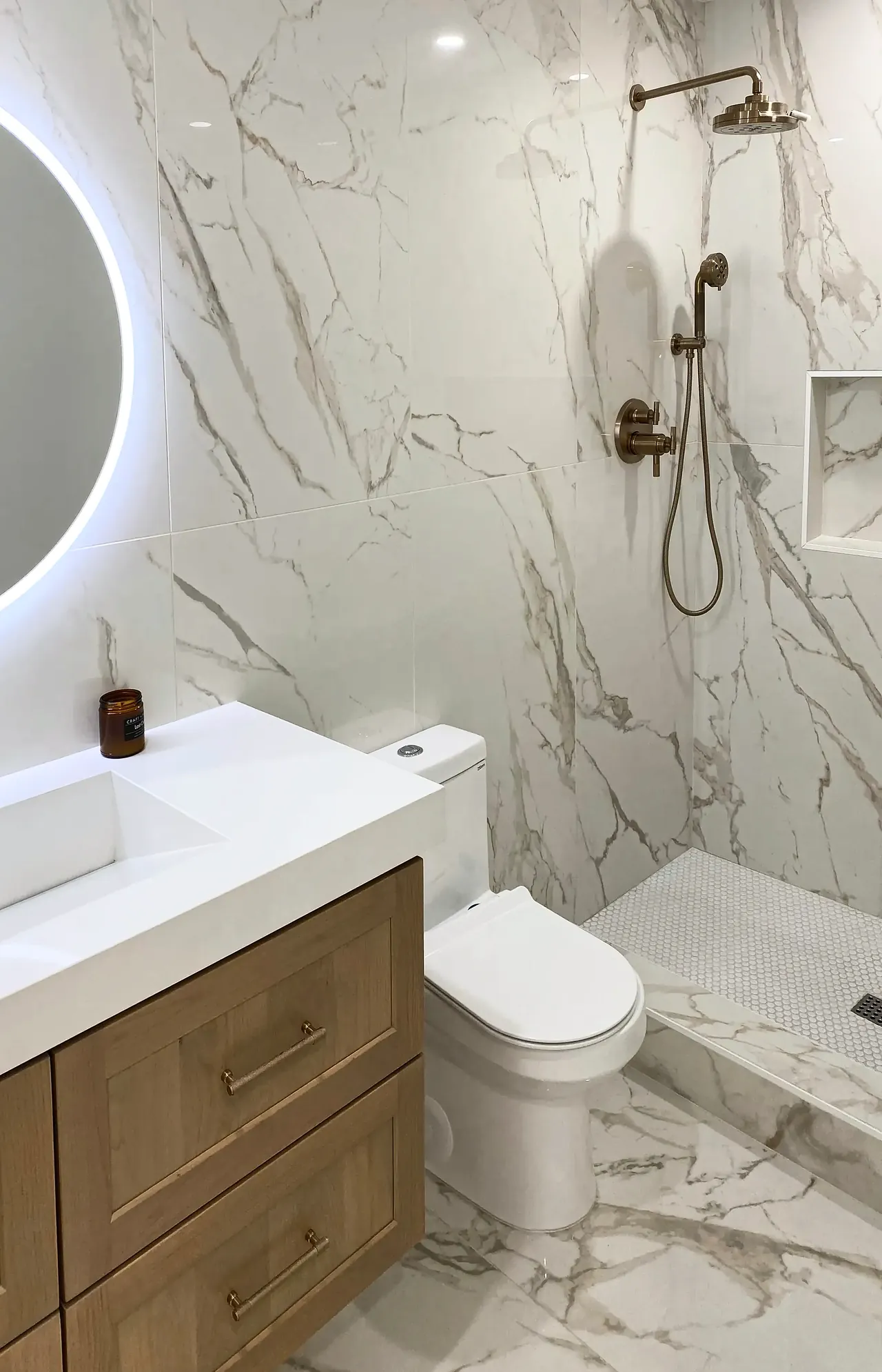 Walk-in shower with a brushed gold rain head and a niche